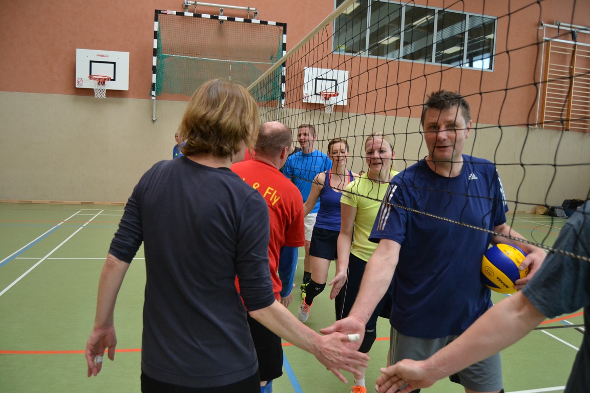 Spieler:innen des SC Hamburg-Mitte begrüßen sich am Netz nach einem Hallentraining